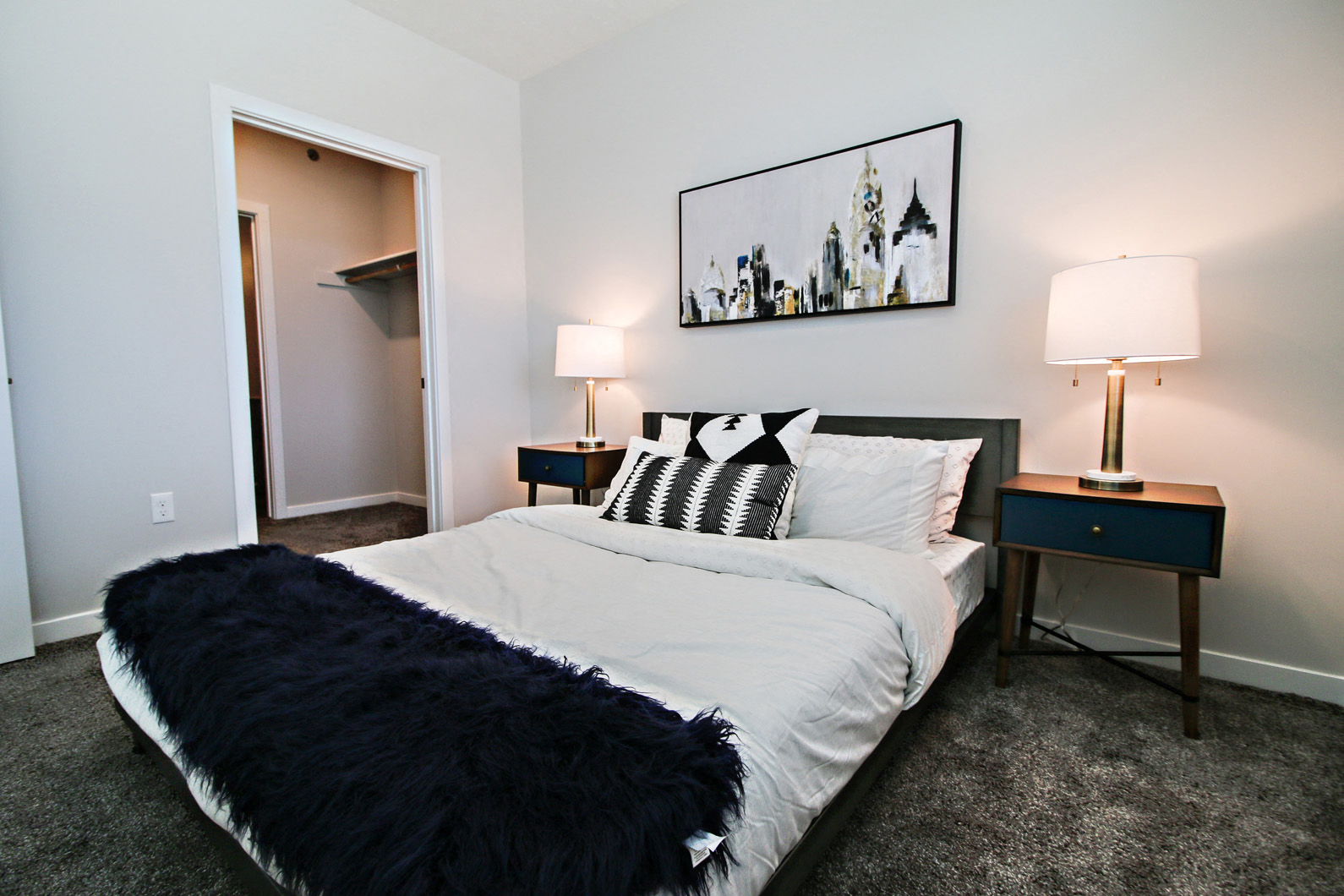 a bedroom with a white bed and black and white comforter
