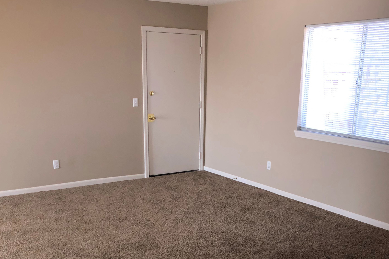 an empty room with a door and a window