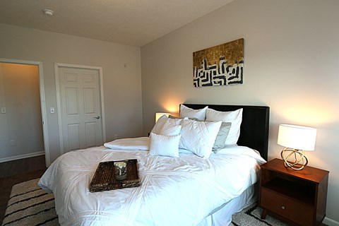 a bedroom with a bed with white sheets and pillows