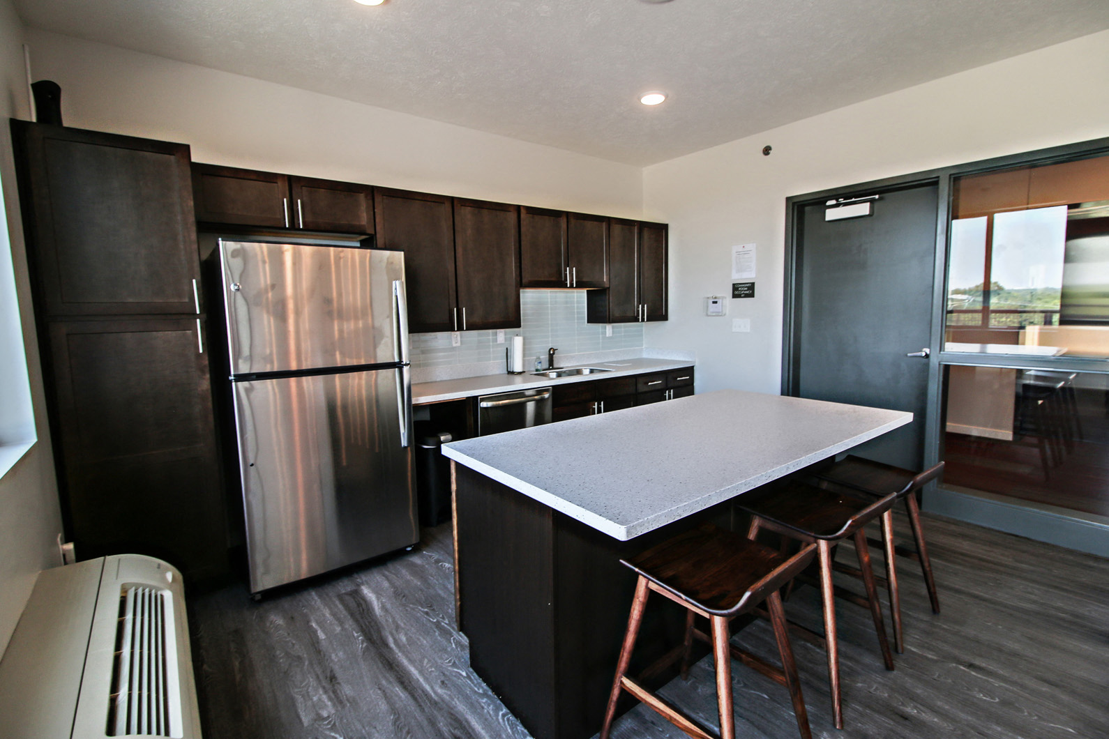 a kitchen with stainless steel appliances and an island with bar stools
