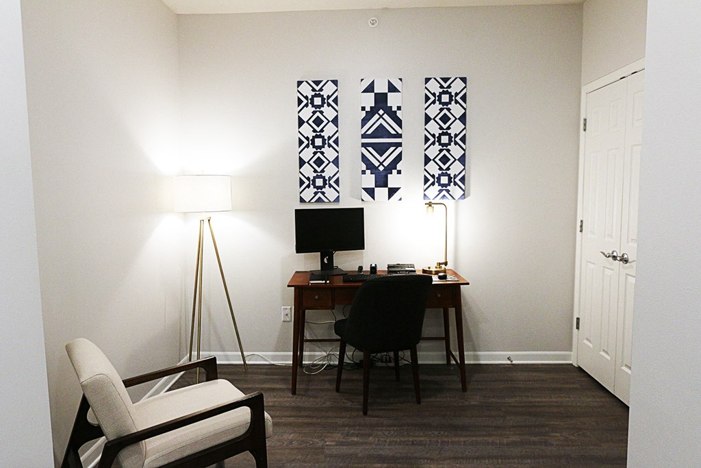 a small room with a desk and a chair and a television