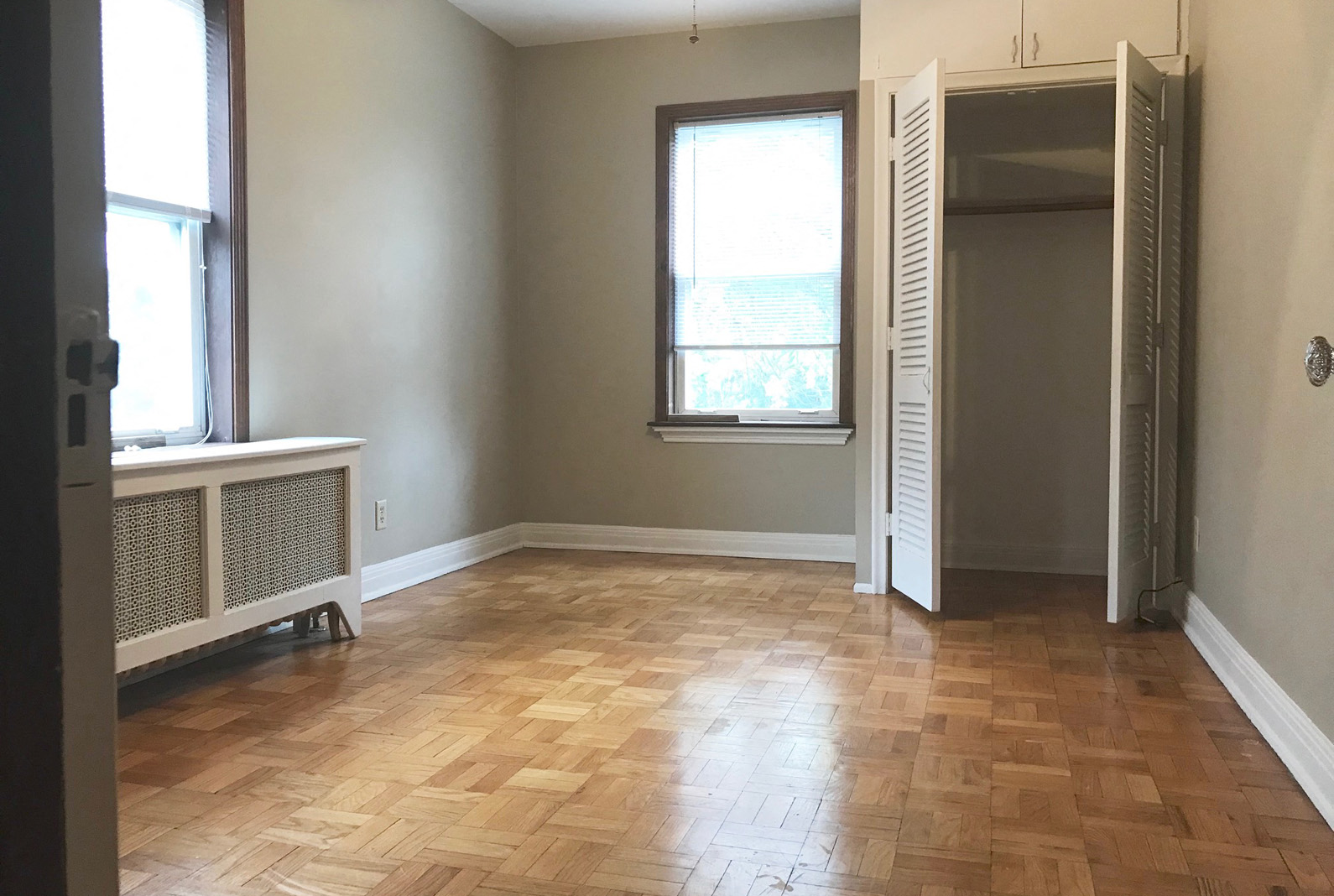 an empty living room with wood floors and a window