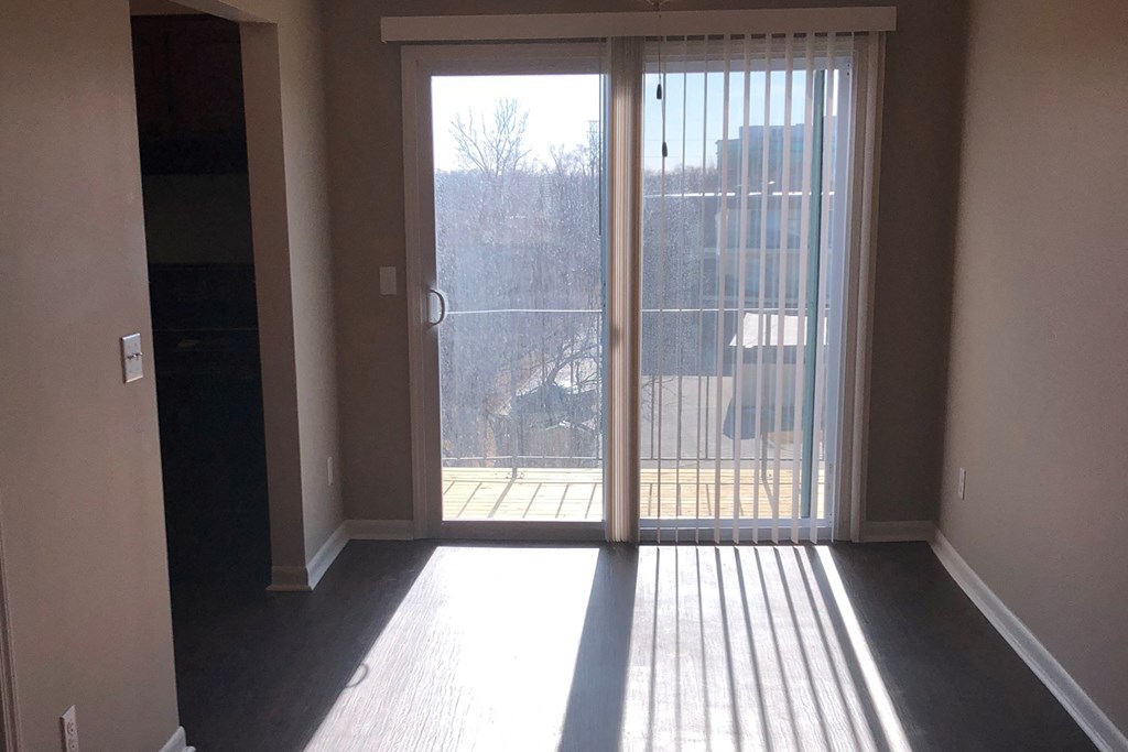 an empty living room with doors to a balcony