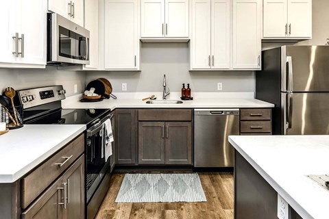a kitchen with stainless steel appliances and white counter tops