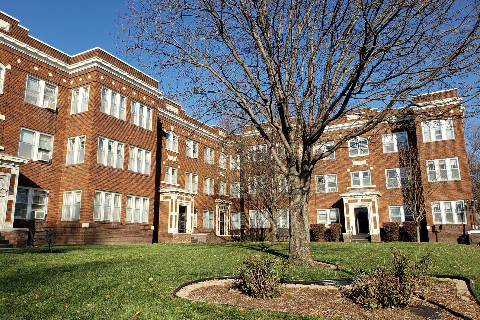 a large brick building with a large tree in front of it