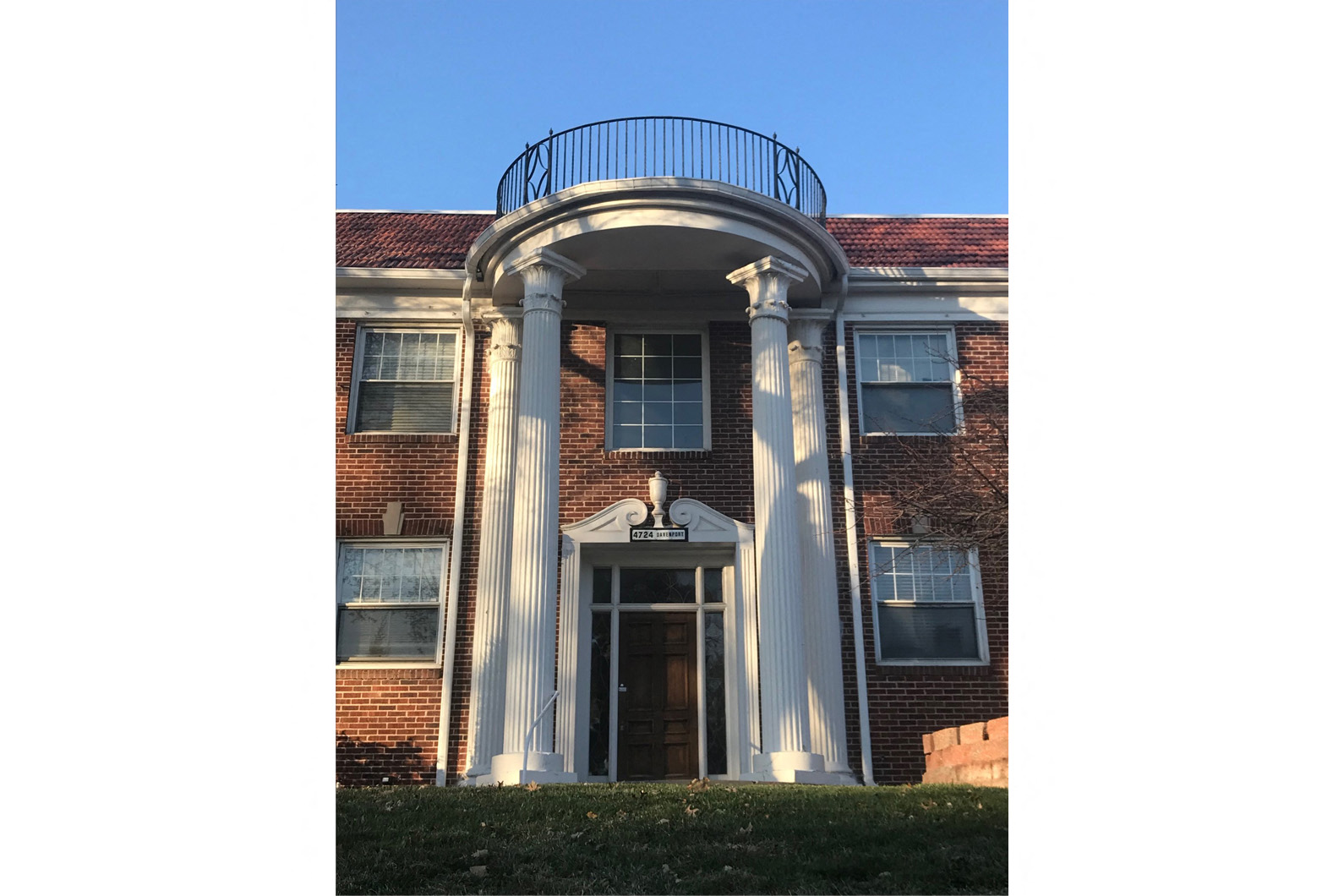 the front of a building with columns and a balcony