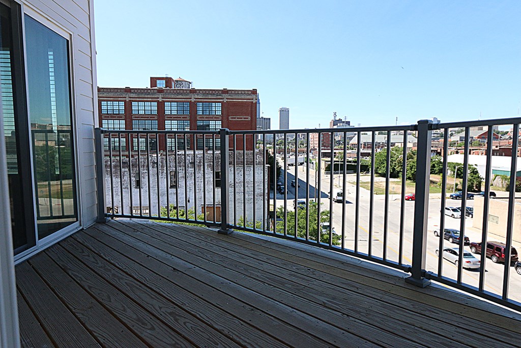 a balcony with a city view and a wooden floor and balcony railings