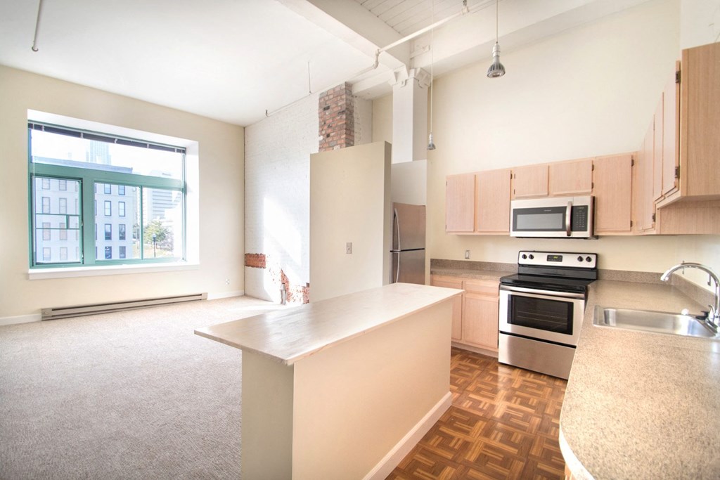 Light kitchen cabinets with extra storage and breakfast bar or kitchen island at The Greenhouse Apartments in Omaha, NE