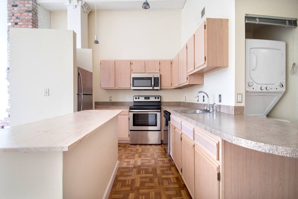 Light kitchen cabinets with extra storage and breakfast bar or kitchen island at The Greenhouse Apartments in Omaha, NE
