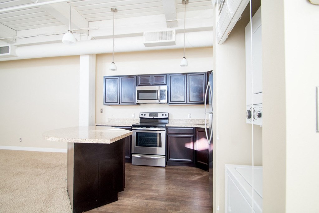Dark kitchen cabinets with extra storage and breakfast bar or kitchen island at The Greenhouse Apartments in Omaha, NE