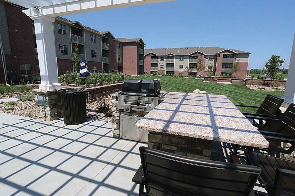 an outdoor patio with a grill and a table with chairs