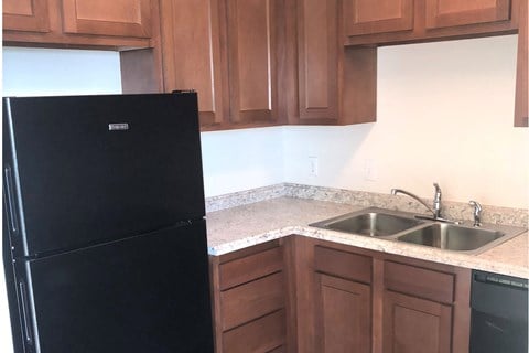 a kitchen with a sink and a black refrigerator