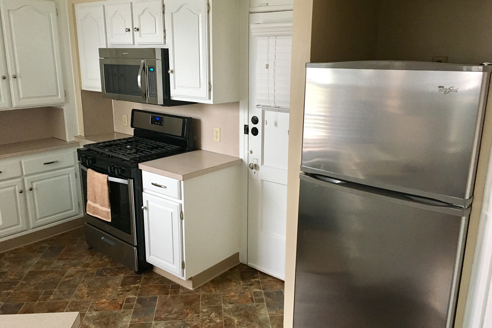 a kitchen with stainless steel appliances and white cabinets