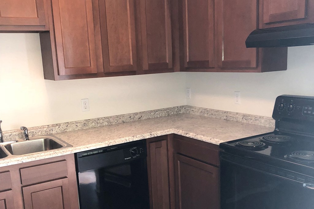 a kitchen with granite counter tops and black appliances
