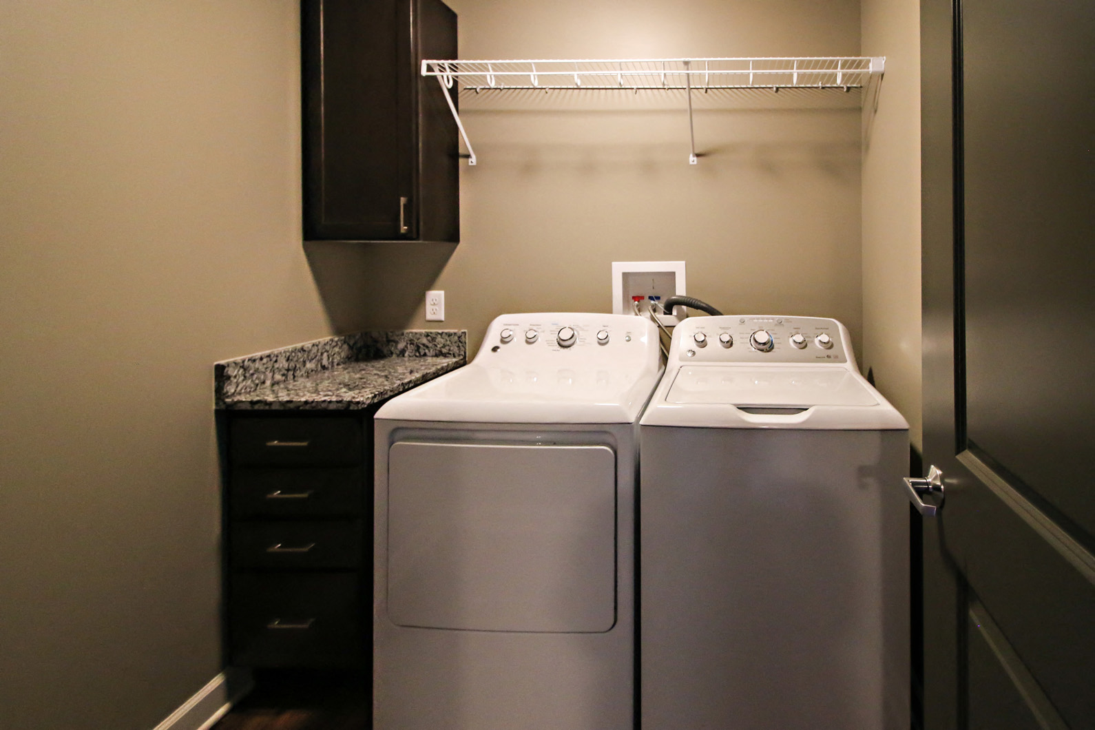 a laundry room with a washer and dryer and a counter with a sink