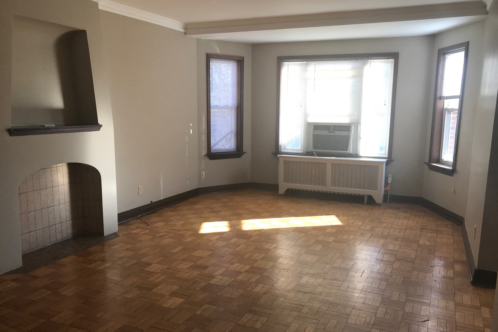 an empty living room with a fireplace and a window