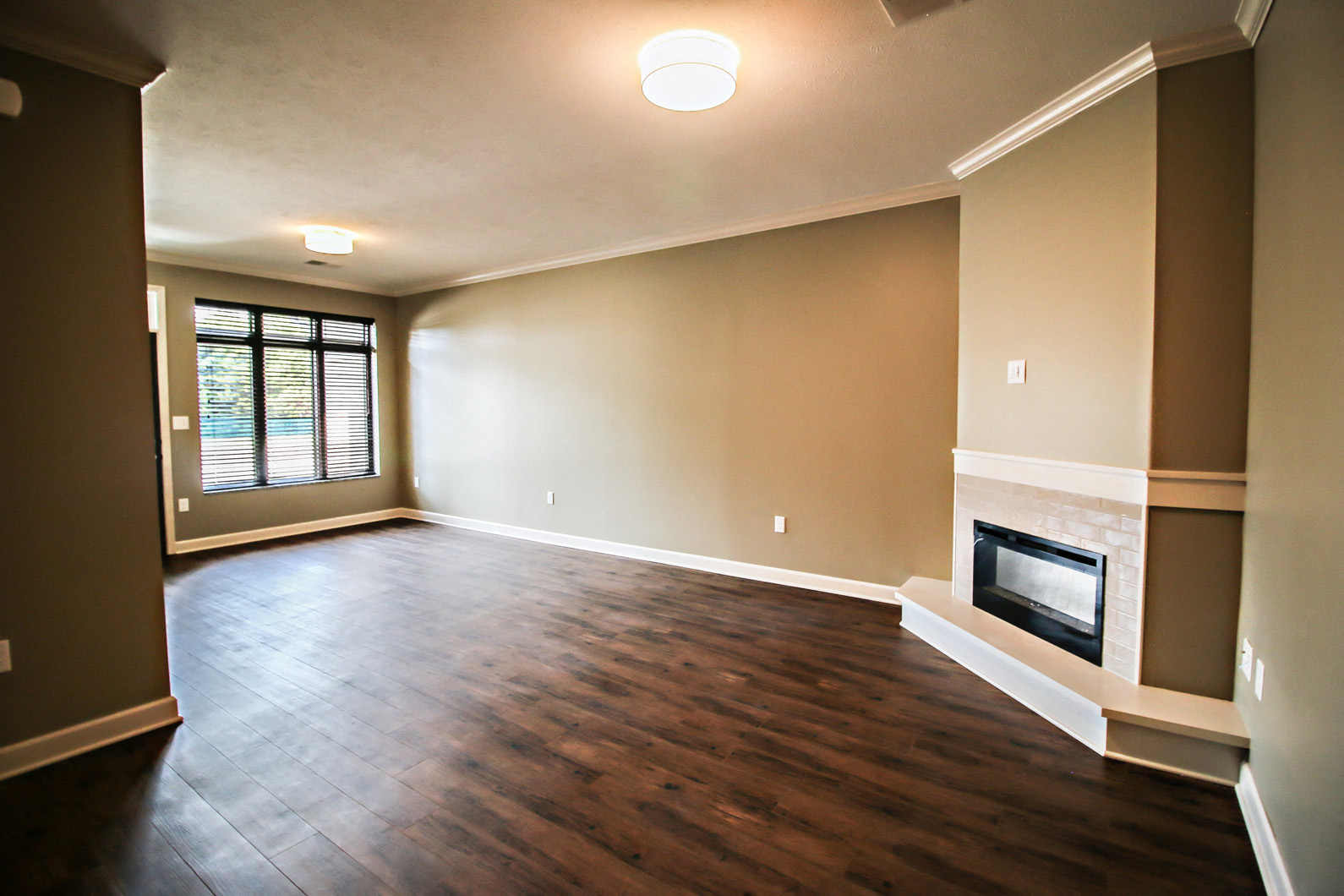 a empty living room with a fireplace and wooden floors