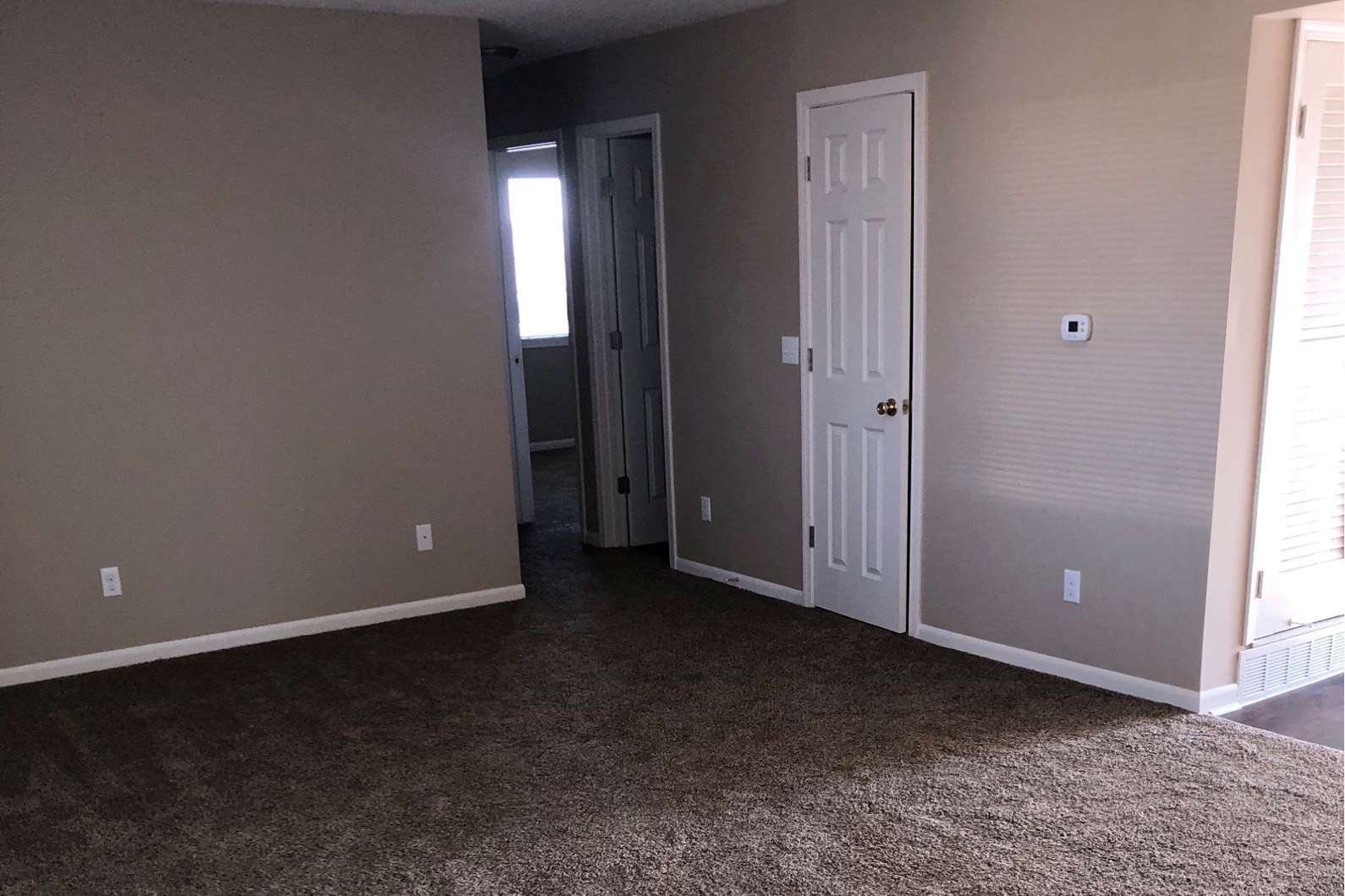 a room with a carpeted floor and a white door