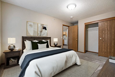 A bedroom with a large bed and a wooden headboard.