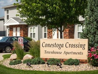 a sign for concession crossing townhouse apartments in front of a house