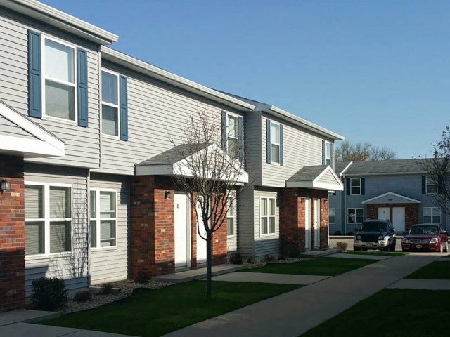 a row of houses with cars parked in front of them