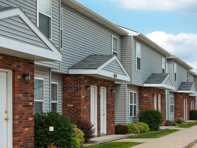 a row of houses with a sidewalk in front of them