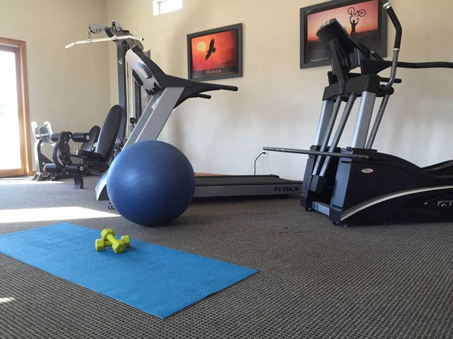a gym with exercise equipment and an exercise ball on the floor