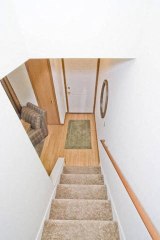 the stairs in a house with a clock on the wall