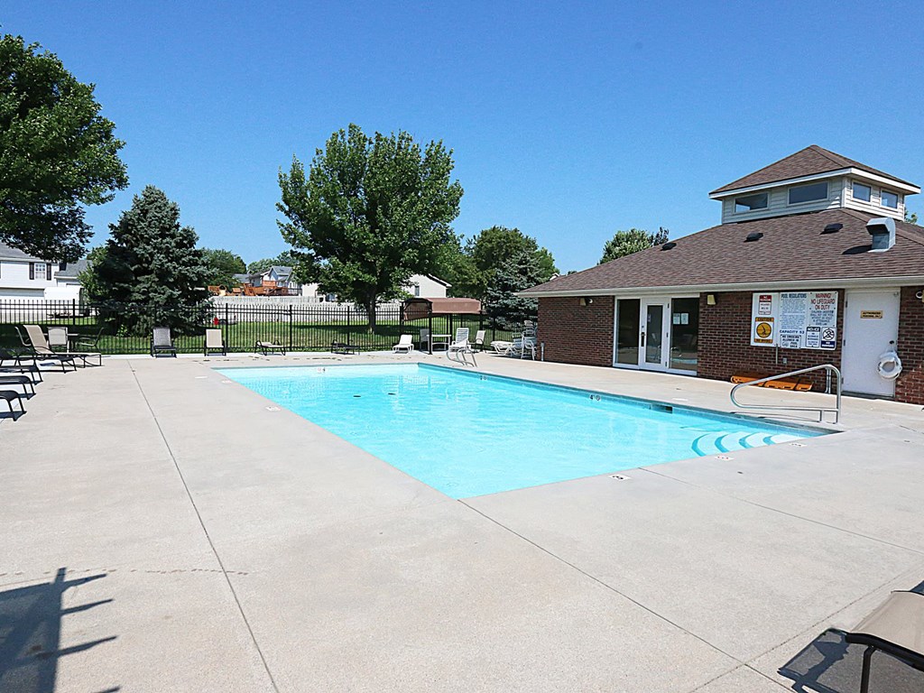 a swimming pool with a house in the background
