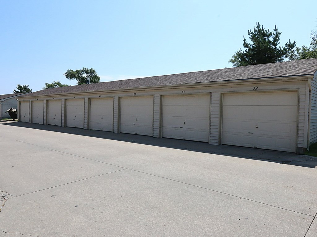 a row of white garage doors on the side of a building
