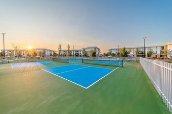 A tennis court with a blue surface and white boundary lines.
