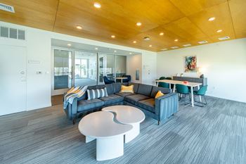 A modern living room with a grey sofa and a white coffee table.