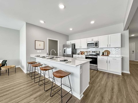 A modern kitchen with white cabinets and a long island.