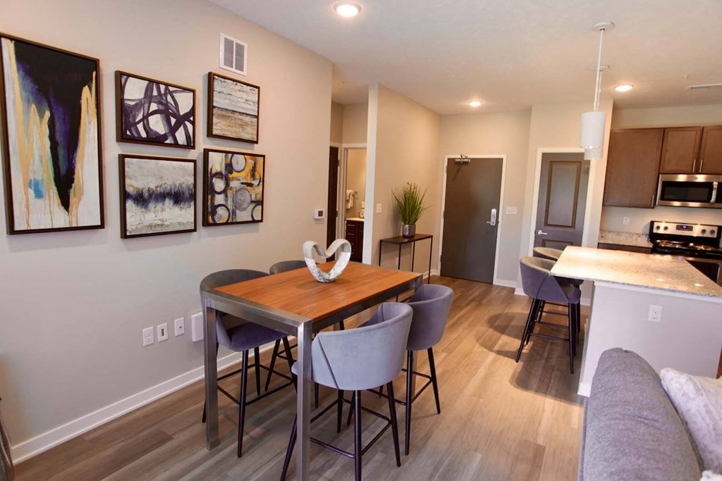 A dining room with a table and chairs.