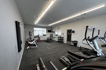 A gym with treadmills, elliptical machines, and other exercise equipment.
