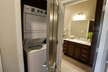 A modern kitchen with a washing machine and dryer built into the cabinetry.