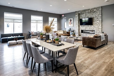 A modern dining room with a stone fireplace and a large table set for six.