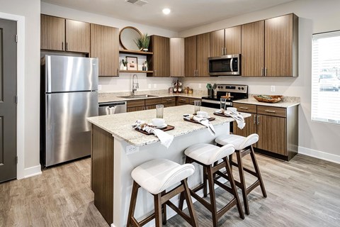 A kitchen with a table and chairs in front of it.