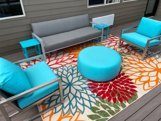 a patio with a couch and chairs on a rug