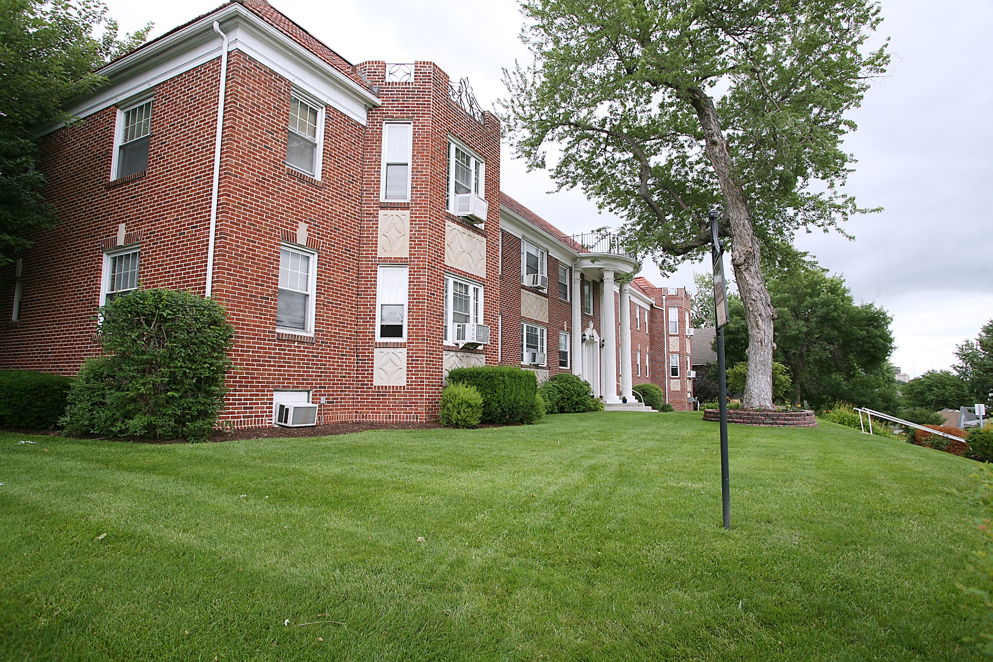 a large brick building with a lawn in front of it