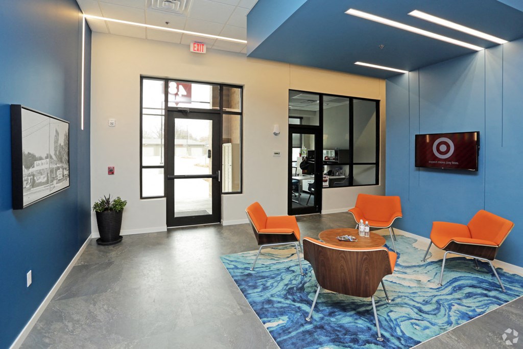 a conference room with blue walls and orange chairs and a table