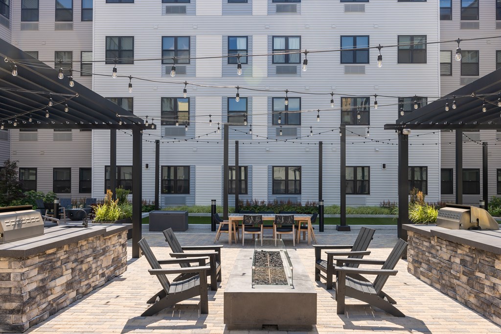 A patio with a table and chairs is in front of a building.