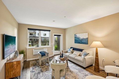 A living room with a white couch, a coffee table, and a painting on the wall.