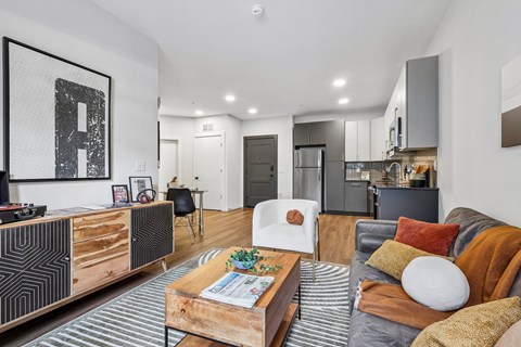 A modern living room with a grey couch and a wooden coffee table.