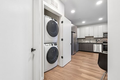 A modern laundry room with a washer and dryer built into the cabinetry.