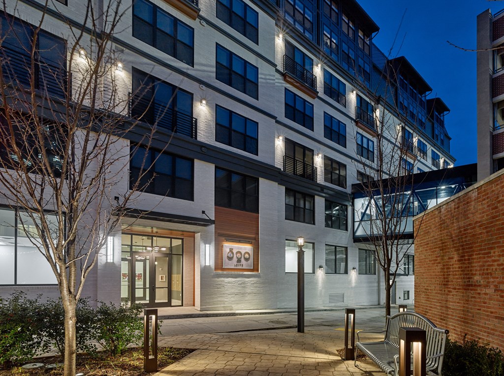 an apartment building at night with a sidewalk and benches at 520 Lofts, Allentown