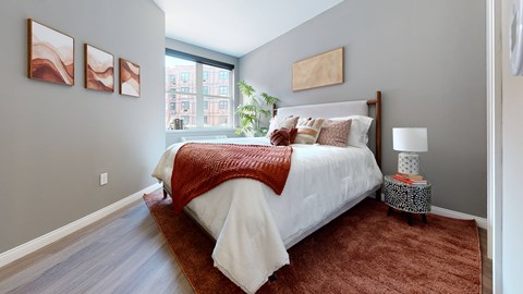 A bedroom with a large bed and a red blanket.
