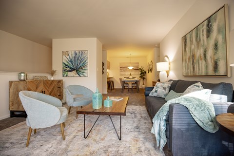 A living room with a grey couch and a wooden coffee table.