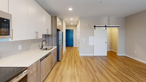 A kitchen with wooden floors and a blue door.