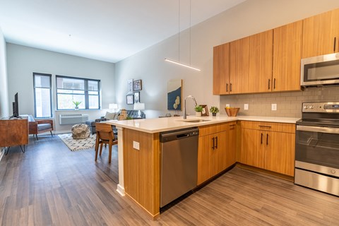A modern kitchen with wooden cabinets and stainless steel appliances.